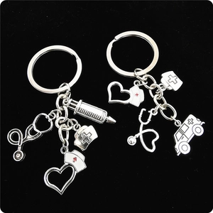 Detailed silver medical keychains featuring nurse cap, syringe, and heart charms on velvet