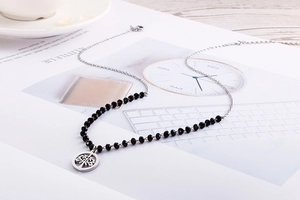 Detail of Tree of Life pendant necklace with black faceted beads on a silver chain