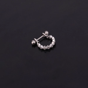 Macro shot of silver U-shaped cartilage earring with square zircons on black background
