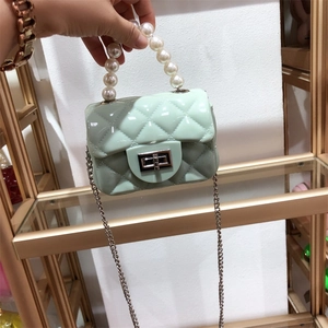 Detail of light green PVC mini jelly bag with pearl handle and metal chain strap