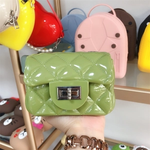 Close-up of green mini PVC jelly bag with quilted texture and gold pearl handle