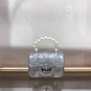 Close-up of mini silver glitter jelly bag with pearl handle and quilted texture details