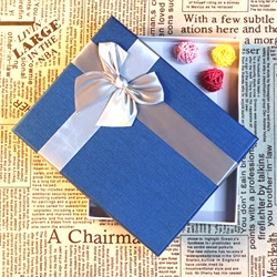 Blue textured gift box with silver ribbon and colorful small woven balls inside