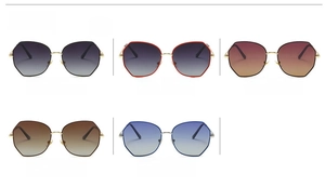 Multiple pairs of oversized polygonal sunglasses in gold frames with gradient lenses