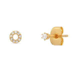 Detail of gold asymmetrical stud earrings featuring open circle pavé and six-prong solitaire