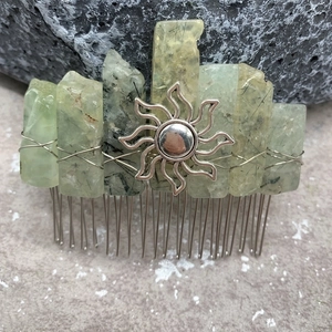 Detail of handmade hair comb with natural green crystals and gold sun charm decoration