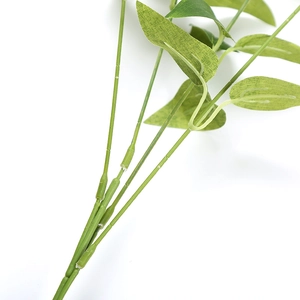 Close-up of the realistic green plastic stem and textured fabric leaves of the plant