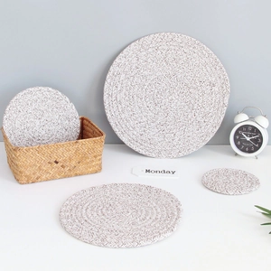 Detailed close-up of cream woven cotton coasters and placemats in a home setting