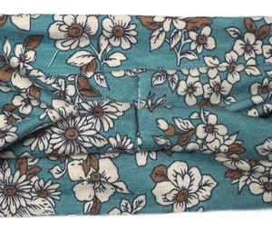 Close-up of teal floral printed wide headband featuring a stylish central twist detail