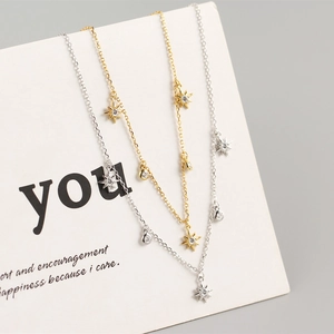 Detail of three layering necklaces with star pendants and round zirconia crystals