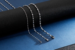 Detailed close-up of various thickness silver stainless steel ball chains for men