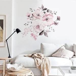 Detail of watercolor pink flowers and grey leaves wall stickers in a cozy living room decor
