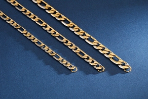 Makroaufnahme von drei gold-silbernen Figaro-Halsketten mit polierter Metalloberfläche