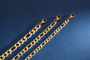 Detailansicht von drei goldenen Edelstahl NK-Figaroketten mit Karabinerverschluss