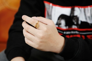 Detailed close-up of a golden dragon wing ring with intricate textures and gothic design