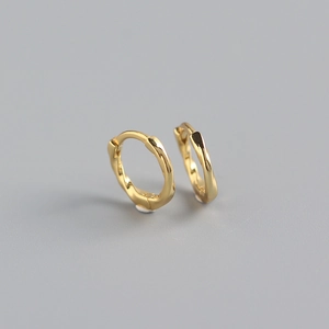 Detailed close-up of golden S925 sterling silver ear cuffs with twisted texture design