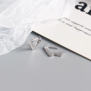 Close-up of S925 sterling silver triangle earrings with inlaid zircon and hallmark