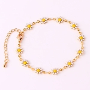 Detailed view of 18K gold daisy bracelet with white enamel petals and adjustable lobster clasp