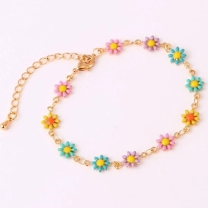 Detail of 18K gold bracelet featuring colorful enamel daisy charms and extension chain