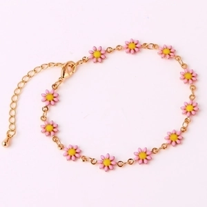 Detailed view of 18K gold chain bracelet featuring small pink enamel daisy flowers