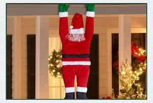 Détail du Père Noël grimpant en tissu rouge, décoration murale pour ambiance de fête