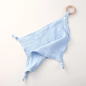 Detailed view of blue cotton gauze baby security blanket with natural wood teething ring
