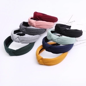Stack of colorful knitted cotton knot headbands for women in various trendy solid colors