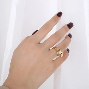 Detailansicht eines goldenen Edelstahlrings mit bösem Blick-Motiv am Finger getragen