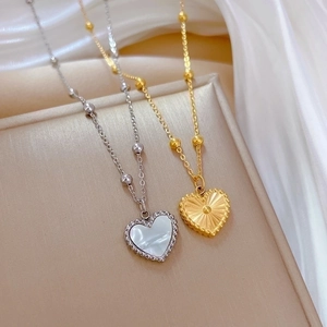 Titanium steel heart necklaces with mother of pearl inlay and gold radiating textures
