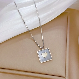Detailed view of square silver necklace pendant with mother of pearl and heart inlay