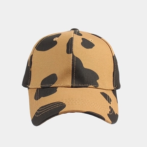 Close-up of khaki baseball cap with black cow print pattern and premium stitching