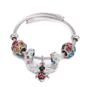 Stainless steel cable bracelet with colorful rhinestone beads and bee pendant on white background