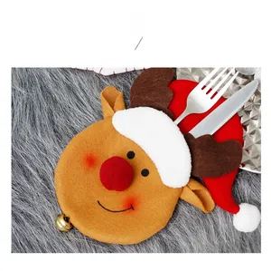 Close-up of reindeer and Santa hat felt cutlery holders with gold bells for table decor