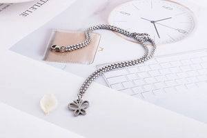 Detailed view of silver stainless steel box chain necklace with hollow butterfly pendant