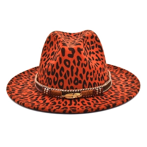 Detail of leopard print fedora featuring orange felt and gold feather pendant charm