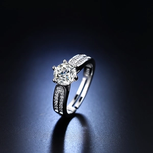 Close-up of elegant six-claw silver ring with round diamond and pavé side stones