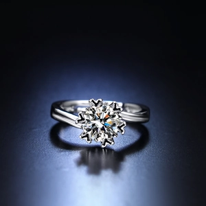 Macro shot of silver six-prong cubic zirconia ring on reflective blue background