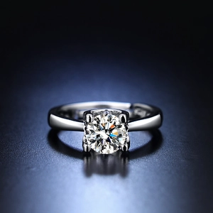 Macro shot of silver ring with four-prong setting and round transparent gemstone