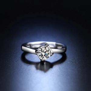 Macro shot of silver ring featuring a classic four-prong setting with a brilliant diamond
