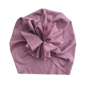 Detail view of the ribbed cotton fabric and oversized flower on this rose baby turban hat