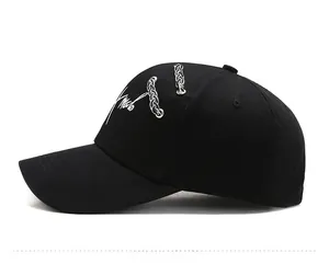 Detail of black canvas baseball cap with side embroidery and silver metal chain