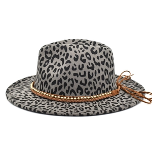 Detail of leopard print fedora hat featuring brown leather braid and gold beaded metal chain