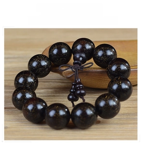 Detailed close-up of dark blood sandalwood beads with gold specks and gourd pendant