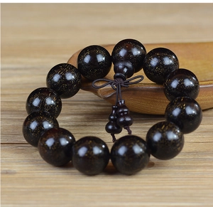 Macro detail of dark brown sandalwood prayer beads with fine golden star textures