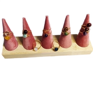 Handmade copper wire wrapped rings with natural crystal stones on pink velvet stands