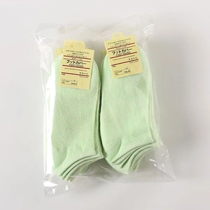 Detail of light green cotton low-cut invisible socks in two-pack transparent packaging