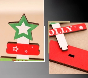 Close-up of DIY wooden Christmas tree decor with HOLLY lettering and laser-cut star