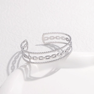 Detail view of silver multi-layer stainless steel C-shape bangle with bead and paperclip chain