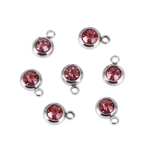 Macro detail of seven pink birthstone pendants with silver stainless steel settings