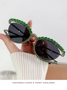 Dettaglio di occhiali da sole alla moda con strass verdi brillanti sulla montatura in metallo